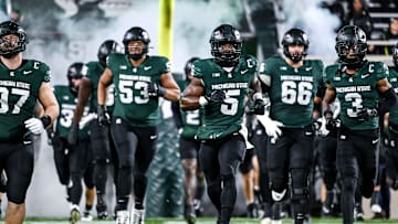 Michigan State's Nathan Carter, center, and the team take the field before the football game against Purdue on Friday, Nov. 22, 2024, at Spartan Stadium in East Lansing.