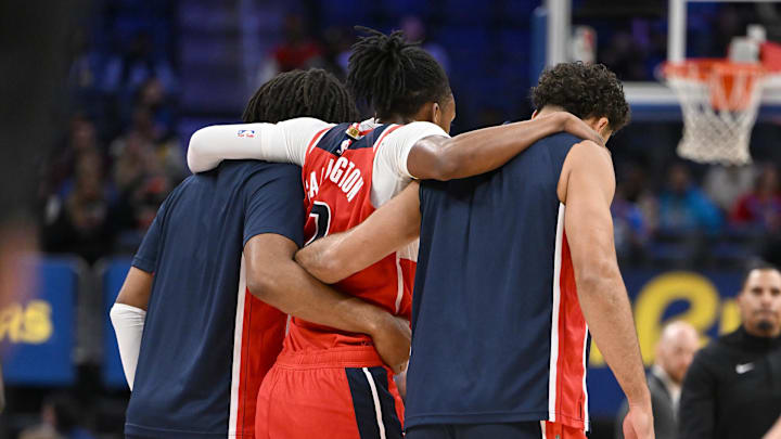 Oct 16, 2025; Detroit, Michigan, USA; Washington Wizards guard Bub Carrington (7) is helped off the court after injuring his leg against the Detroit Pistons in the first half at Little Caesars Arena. Mandatory Credit: Lon Horwedel-Imagn Images