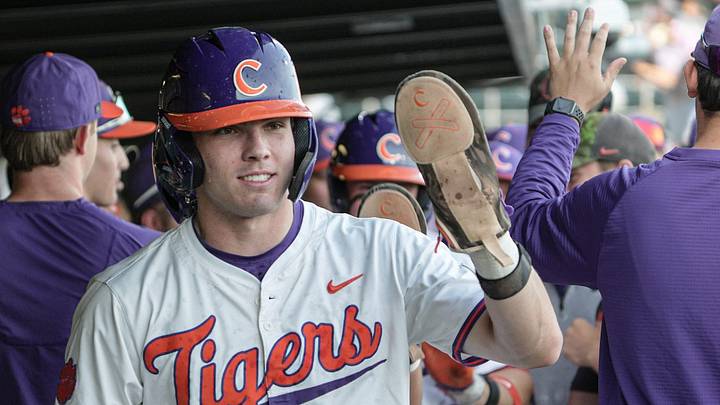 Clemson catcher Nate Savoie (99) is congratulated by teammates after scoring during the bottom of the first inning at Doug Kingsmore Stadium in Clemson, S.C. Tuesday, April 21, 2026.