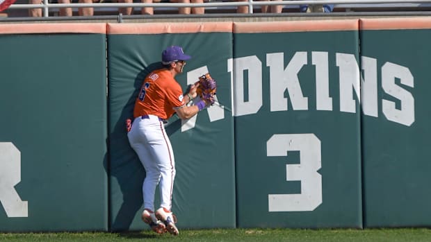 Clemson outfielder Dominic Listi (6) makes a catch at the left field wall against University of Louisville.