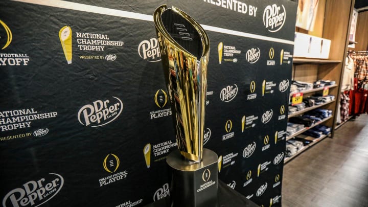 Fans stop to take photos with the College Football National Championship trophy at Meijer in Ypsilanti, Mich. on Thursday, Jan. 11, 2024. The trophy is going on a tour for fans to see presented by Dr. Pepper.