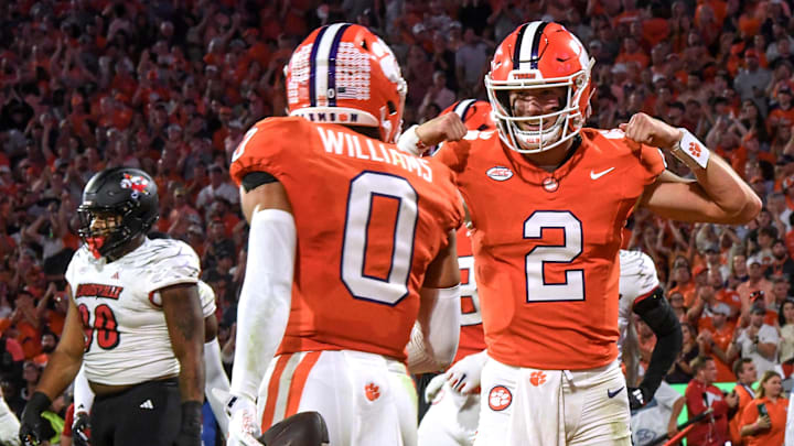 Nov 2, 2024; Clemson, South Carolina, USA; Clemson Tigers quarterback Cade Klubnik (2) celebrates after throwing a touchdown pass to wide receiver Antonio Williams (0) against the Louisville Cardinals during the first quarter at Memorial Stadium. Mandatory Credit: Ken Ruinard-Imagn Images