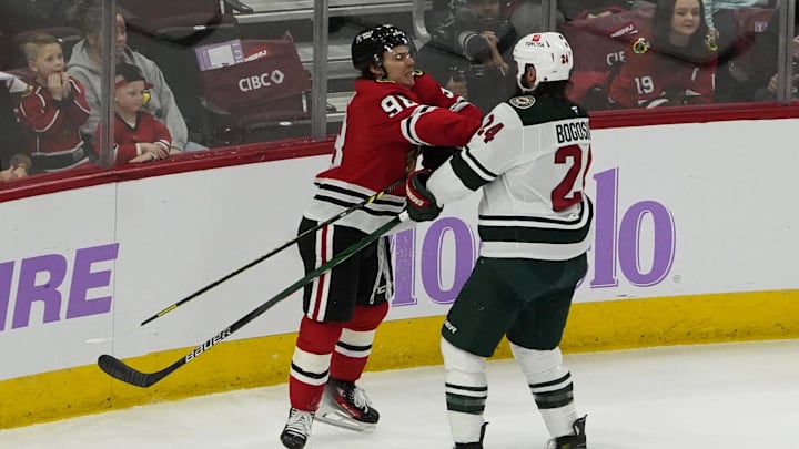 Jan 26, 2025; Chicago, Illinois, USA; Chicago Blackhawks center Connor Bedard (98) checks Minnesota Wild defenseman Zach Bogosian (24) go for the puck during the third period at United Center. Mandatory Credit: David Banks-Imagn Images