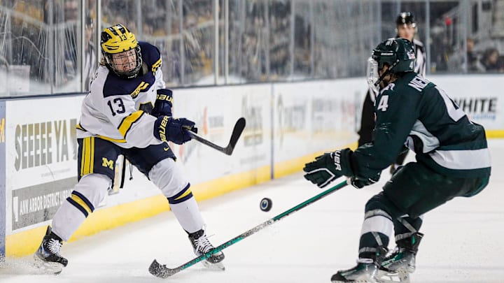 Michigan center TJ Hughes makes a pass against Michigan State defenseman Nash Nienhuis during the third period at Yost Ice Arena in Ann Arbor on Friday, Feb. 9, 2024.
