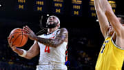 Mar 2, 2025; Ann Arbor, Michigan, USA;  Illinois Fighting Illini guard Kylan Boswell (4) drives to the basket past Michigan Wolverines center Vladislav Goldin (50) in the second half at Crisler Center. Mandatory Credit: Lon Horwedel-Imagn Images