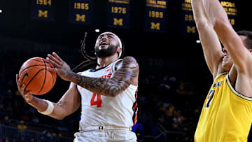 Mar 2, 2025; Ann Arbor, Michigan, USA;  Illinois Fighting Illini guard Kylan Boswell (4) drives to the basket past Michigan Wolverines center Vladislav Goldin (50) in the second half at Crisler Center. Mandatory Credit: Lon Horwedel-Imagn Images
