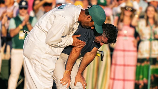 Um emocional Rory McIlroy (à direita) é consolado por seu caddie.