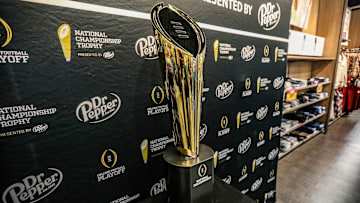 Fans stop to take photos with the College Football National Championship trophy at Meijer in Ypsilanti, Mich. on Thursday, Jan. 11, 2024. The trophy is going on a tour for fans to see presented by Dr. Pepper.