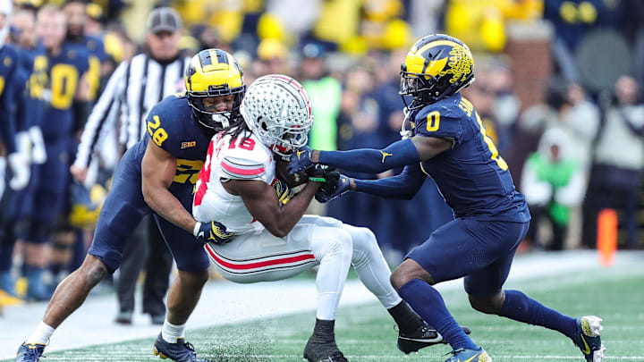 Ohio State wide receiver Marvin Harrison Jr. (18) makes a catch against Michigan defensive back Quinten Johnson (28) and defensive back Mike Sainristil (0) during the second half at Michigan Stadium in Ann Arbor on Saturday, Nov. 25, 2023.