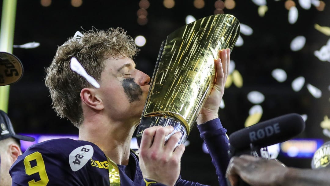 Michigan quarterback J.J. McCarthy kisses the championship trophy to celebrate the Wolverines' 34-13 win over Washington in the national championship game at NRG Stadium in Houston on Monday, Jan. 8, 2024.