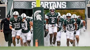 Michigan State's Aidan Chiles, center, and the Spartans take the field before the game against UCLA on Saturday, Oct. 11, 2025, at Spartan Stadium in East Lansing.