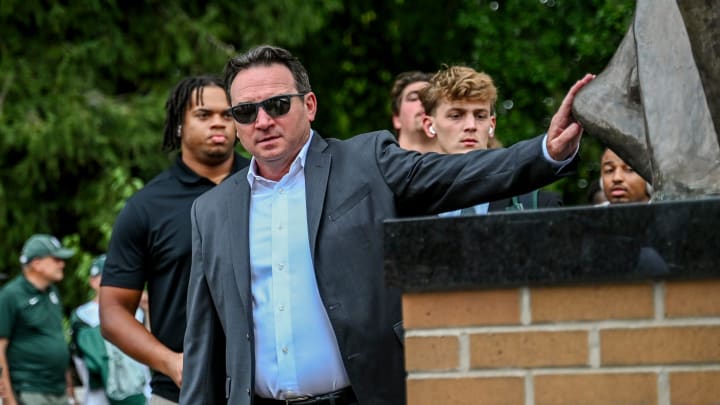 Michigan State's head coach Jonathan Smith touches the foot of the Sparty statue before the game against Florida Atlantic on Friday, Aug. 30, 2024, outside Spartan Stadium in East Lansing.