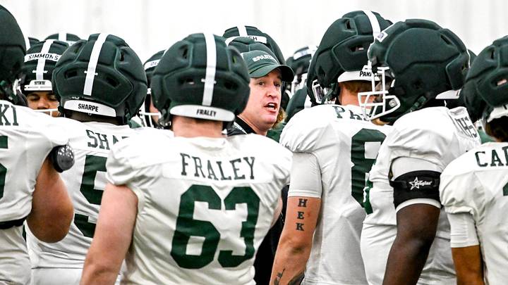 Michigan State's head coach Pat Fitzgerald, center, huddles up with the team during spring football practice on Tuesday, April 14, 2026, in East Lansing.