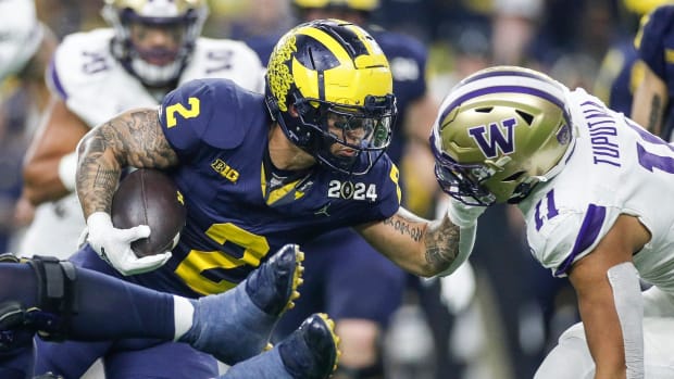 Michigan running back Blake Corum runs against Washington linebacker Alphonzo Tuputala in the 2023 national championship game