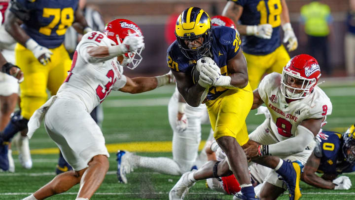 Michigan running back Kalel Mullings (20) runs in between Fresno State defensive back Dean Clark (32) and Fresno State linebacker Malachi Langley (9) during the second half at Michigan Stadium in Ann Arbor on Saturday, Aug. 31, 2024.