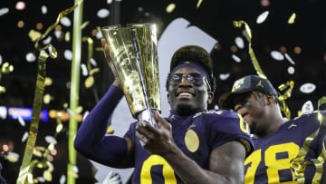 Michigan defensive back Mike Sainristil lifts the trophy to celebrate the 34-13 win over Washington at the national championship game at NRG Stadium in Houston on Monday, Jan. 8, 2024.