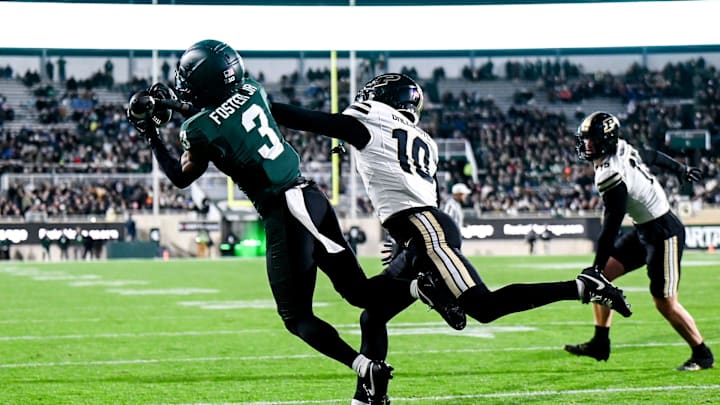 Michigan State's Montorie Foster Jr., left, catches a touchdown as Purdue's Kyndrich Breedlove defends during the first quarter on Friday, Nov. 22, 2024, at Spartan Stadium in East Lansing.