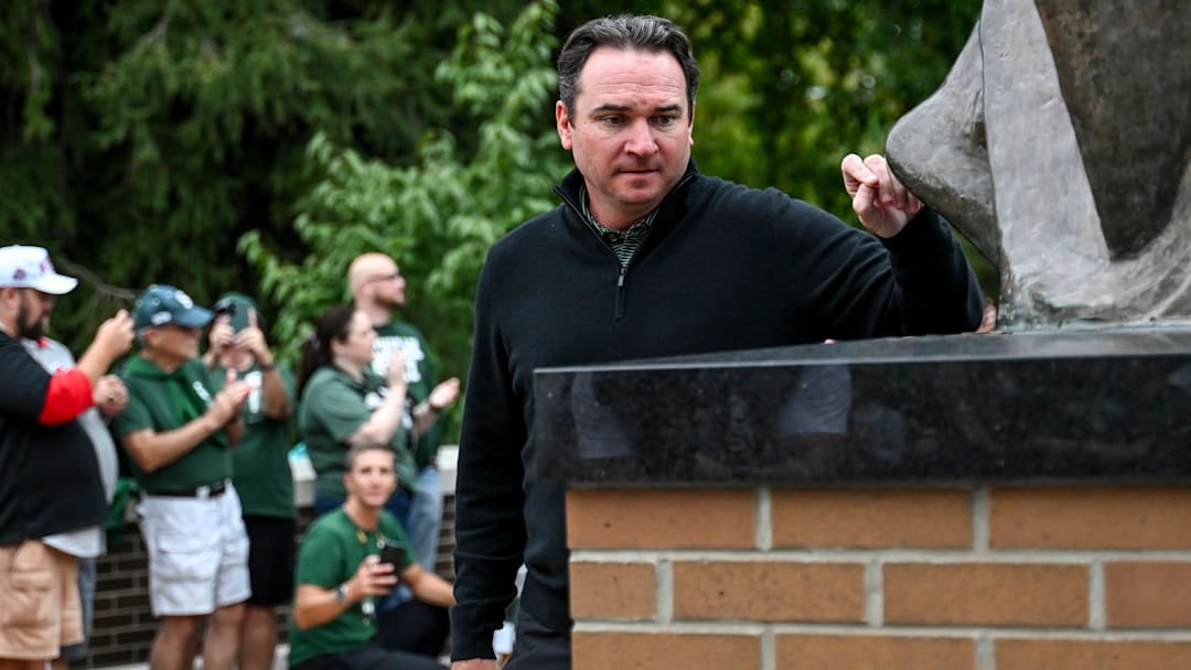 Michigan State's head coach Jonathan Smith throws a penny at the foot of the Sparty statue before the start of the football game against Ohio State on Saturday, Sept. 28, 2024, on his way to Spartan Stadium in East Lansing.