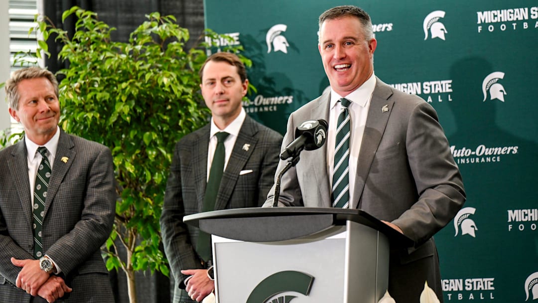 Michigan State's new football coach Pat Fitzgerald talks during his introductory press conference on Tuesday, Dec. 2, 2025, at the Tom Izzo Football Building in East Lansing. MSU athletic director J Batt, center, and MSU president Kevin Guskiewicz, left, look on.