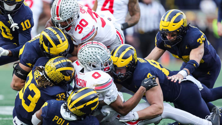 Ohio State receiver Xavier Johnson is piled on by the Michigan defense during the second half at Michigan Stadium in Ann Arbor on Saturday, Nov. 25, 2023.