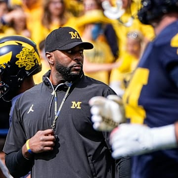 Michigan head coach Sherrone Moore, center, watches warm up before the Texas game at Michigan Stadium in Ann Arbor on Saturday, September 7, 2024.