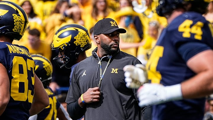 Michigan head coach Sherrone Moore, center, watches warm up before the Texas game at Michigan Stadium in Ann Arbor on Saturday, September 7, 2024.