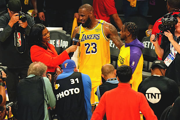 LeBron and Bronny James are interviewed and surrounded by cameras after their historic moment.