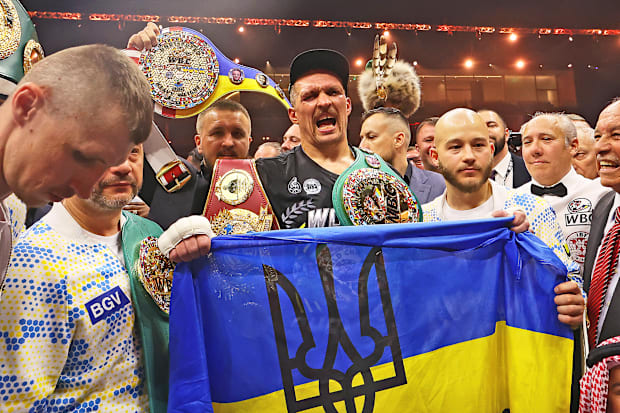 Oleksandr Usyk holds up a Ukrainian flag after beating Tyson Fury