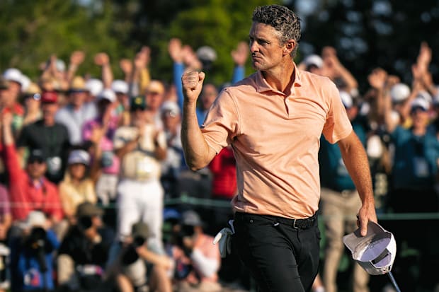 Justin Rose fist pumps in the direction of the crowd after making a putt on the 18th hole.