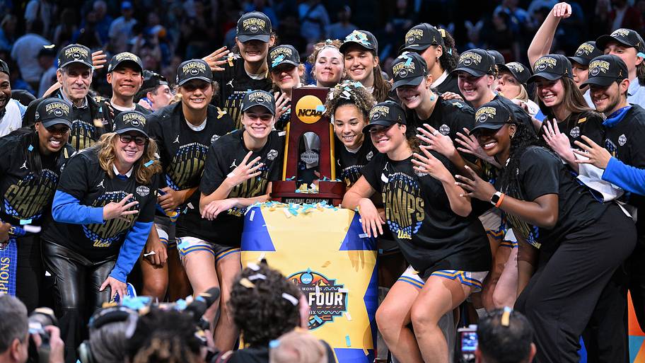 UCLA women's players pose with the championship trophy