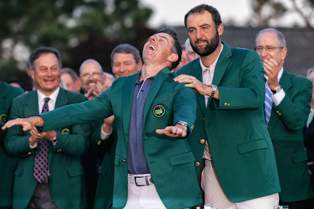 2024 Masters winner Scottie Scheffler (right) places the green jacket on Rory McIlroy.