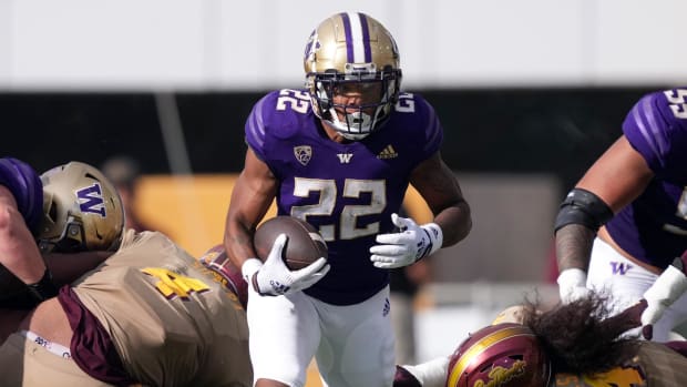Washington Huskies running back Cameron Davis on a rushing attempt during a college football game.