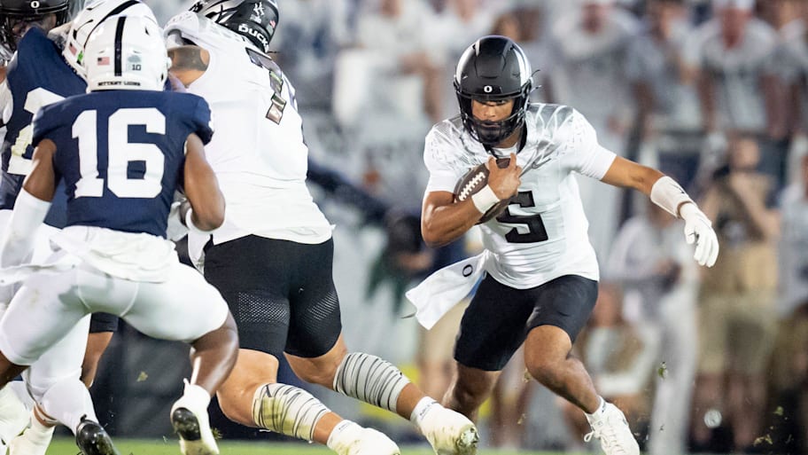 Oregon quarterback Dante Moore carries the ball.