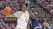 Jan 18, 2025; Tallahassee, Florida, USA;  Florida State Seminoles forward Malique Ewin (12) drives the ball past Georgia Tech Yellowjackets forward Baye Ndongo (11) during the first half at Donald L. Tucker Center. Mandatory Credit: Robert Myers-Imagn Images