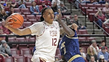 Jan 18, 2025; Tallahassee, Florida, USA;  Florida State Seminoles forward Malique Ewin (12) drives the ball past Georgia Tech Yellowjackets forward Baye Ndongo (11) during the first half at Donald L. Tucker Center. Mandatory Credit: Robert Myers-Imagn Images