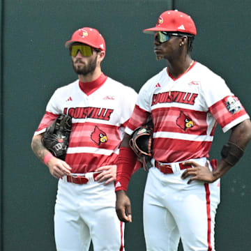 Jun 18, 2025; Omaha, Neb, USA;  Louisville Cardinals left fielder Zion Rose (32), center fielder Lucas Moore (53), and right fielder Eddie King Jr. (42) wait out a pitching change sixth inning at Charles Schwab Field. Mandatory Credit: Steven Branscombe-Imagn Images