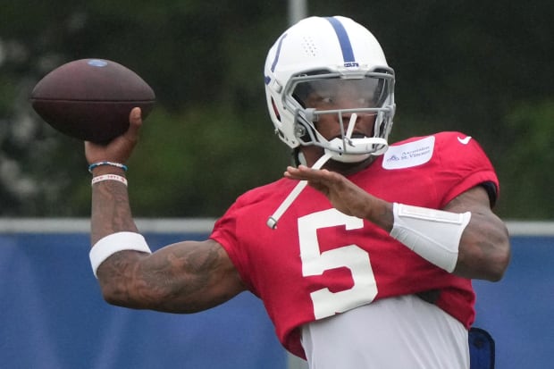 Football player Anthony Richardson throws the ball during practice in a red jersey.