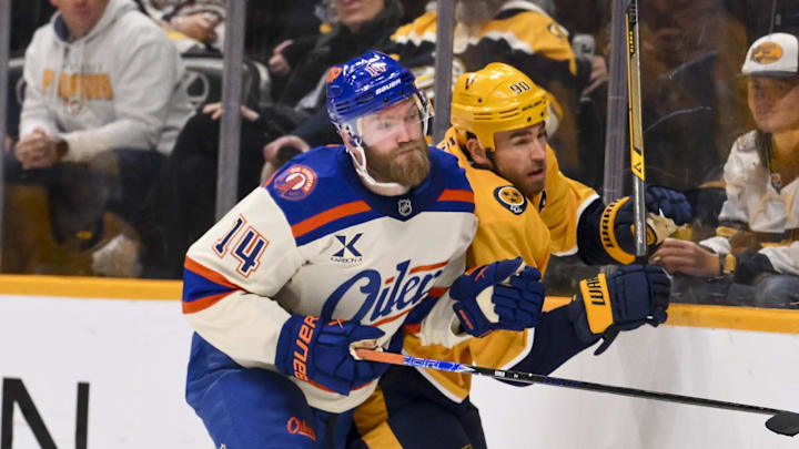 Jan 13, 2026; Nashville, Tennessee, USA;  Edmonton Oilers defenseman Mattias Ekholm (14) checks Nashville Predators center Ryan O'Reilly (90) during the third period at Bridgestone Arena. Mandatory Credit: Steve Roberts-Imagn Images