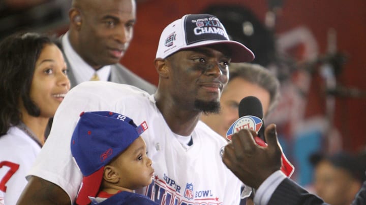 Feb 3, 2008; Glendale, AZ, USA; New York Giants wide receiver Plaxico Burress (17) with his 12-month old son Elijah is interviewed by after winning Super Bowl XLII at the University of Phoenix Stadium. New York Giants defeated the New England Patriots with a final of 17-14.  Mandatory Credit: Matthew Emmons-Imagn Images