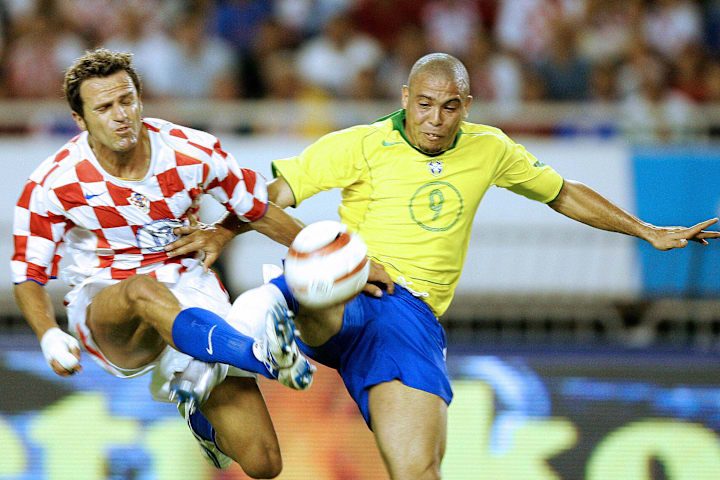 Ronaldo of Brazil (R) fights for the bal