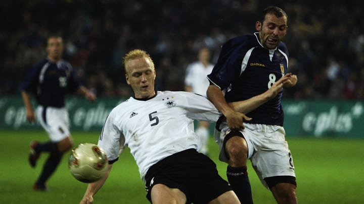 Carsten Ramelow of Germany tackles Colin Cameron of Scotland