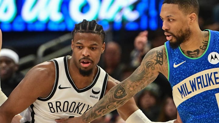 Mar 21, 2024; Milwaukee, Wisconsin, USA; Milwaukee Bucks guard Damian Lillard (0) drives for the basket against Brooklyn Nets guard Dennis Smith Jr. (4) in the fourth quarter at Fiserv Forum. Mandatory Credit: Benny Sieu-USA TODAY Sports