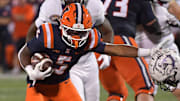 Aug 29, 2025; Champaign, Illinois, USA;  Illinois Fighting Illini running back Ca'Lil Valentine (5) stiff arms Western Illinois Leathernecks defensive back Christian Pierce (3) during the second half at Memorial Stadium. Mandatory Credit: Ron Johnson-Imagn Images