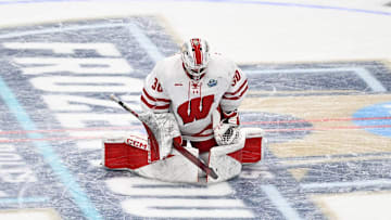 Wisconsin Badgers goaltender Ava McNaughton stretches at center ice before playing against the Minnesota Gophers in an NCAA women's hockey Frozen Four semifinal Friday, March 21, 2025, at Ridder Arena in Minneapolis, Minnesota.