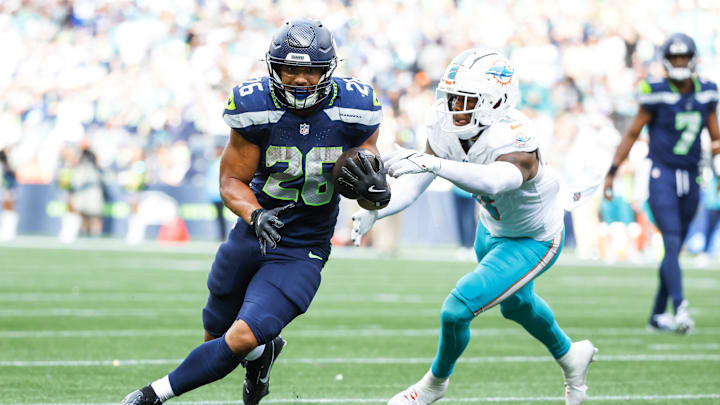 Sep 22, 2024; Seattle, Washington, USA; Seattle Seahawks running back Zach Charbonnet (26) breaks a tackle attempt by Miami Dolphins linebacker Anthony Walker Jr. (6) to rush for a touchdown during the fourth quarter at Lumen Field.