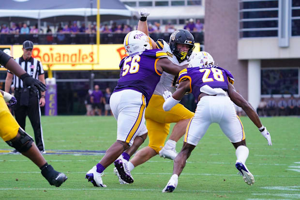 East Carolina Pirates defensive lineman D'Anta Johnson and defensive back Shavon Revel Jr. stop the run .
