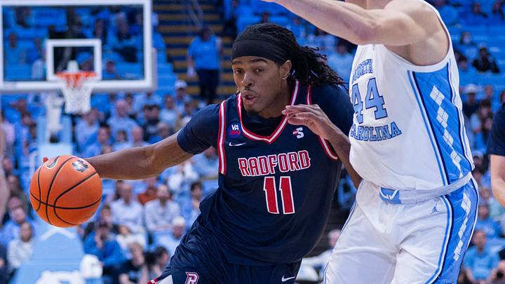 Nov 11, 2025; Chapel Hill, North Carolina, USA; Radford Highlanders guard Jr. Dennis Parker (11) drives on North Carolina Tar Heels guard Luka Bogavac (44) during the first half at Dean E. Smith Center. Mandatory Credit: Scott Kinser-Imagn Images