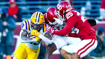 Oklahoma defenders Kip Lewis and Michael Boganowski combine to tackle LSU running back Caden Durham.