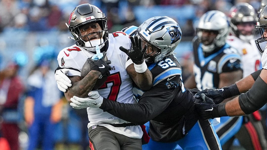 Dec 1, 2024; Charlotte, North Carolina, USA; Tampa Bay Buccaneers running back Bucky Irving (7) is tackled by Carolina Panthers linebacker DJ Johnson (52) during the first quarter at Bank of America Stadium. 