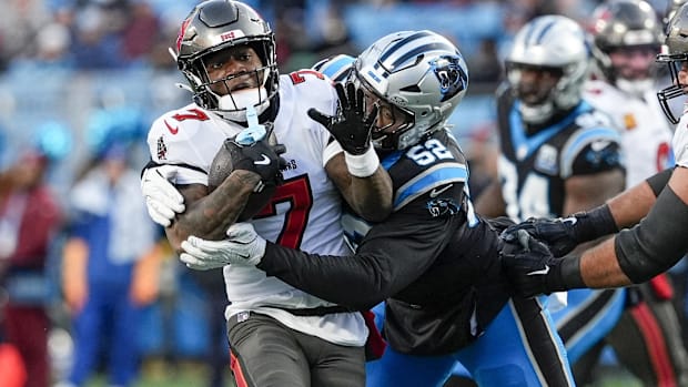 Defensive end DJ Johnson (black and silver helmet) tries to make a tackle